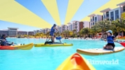 People paddleboarding, kayaking on a man-made lagoon