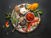 Flat lay overhead view herb and spices in vintage silver plate on textured black background. Asian or indian cuisine colourful spices close up image.