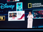 Rita Ferro on stage in a white suit at The Disney Advertising Upfront 2026.