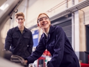 Male And Female Students Looking At Car Engine On Auto Mechanic Apprenticeship Course At College
