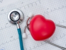 Stethoscope and red heart with cardiogram.