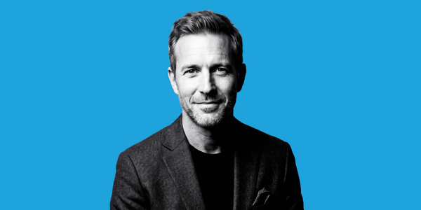 A black and white photo of a man in a blazer
