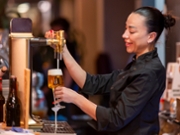 Smiling chef pouring draft beer, ensuring perfect foam and refreshing beverage experience
