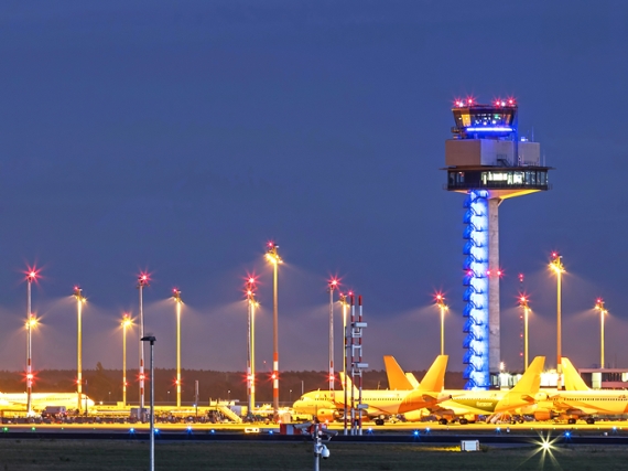Air traffic control tower with many parking aircrafts at airport Berlin-Brandenburg BER