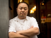 Hooni Kim, chef and restaurateur, poses for a portrait in the doorway of Hanjan restaurant in New York, U.S, on Monday, Feb. 11, 2013. Kim owns two Korean restaurants in New York, Hanjan and Michelin-starred Danji, his first restaurant. Photographer: Philip Lewis/Bloomberg via Getty Images 