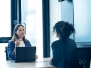 Forecast future talent needs with strategic workforce planning. HR manager conducting an interview and considering women for a new hire in a meeting room of a modern business office.