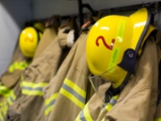 Coats and helmets of fire fighters hanging on hooks