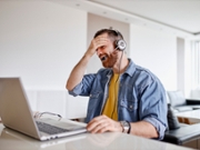 Tired businessman working on laptop at home