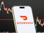 CHONGQING, CHINA - FEBRUARY 07: In this photo illustration, a smartphone displays the logo of DoorDash, Inc. (NYSE: DASH), an American on-demand food delivery and local commerce platform connecting consumers with restaurants and merchants, in front of a screen showing the company's latest stock market chart on February 7, 2026 in Chongqing, China. (Photo illustration by Cheng Xin/Getty Images)