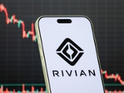 CHONGQING, CHINA - FEBRUARY 3: In this photo illustration, a smartphone displays the logo of Rivian Automotive, Inc. (NASDAQ: RIVN), a U.S.-based electric vehicle manufacturer focused on electric pickup trucks, SUVs and commercial delivery vehicles, in front of a screen showing the company's latest stock market chart on February 3, 2026, in Chongqing, China. (Photo illustration by Cheng Xin/Getty Images)