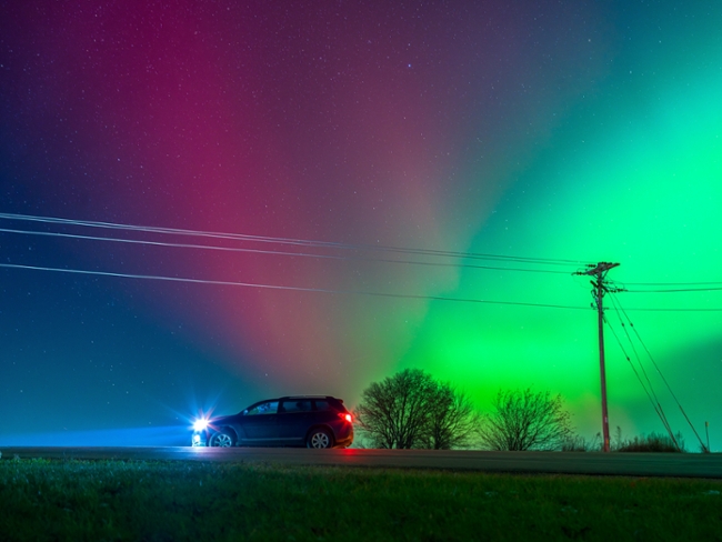 The Aurora Borealis lights up the night sky over Monroe, Wisconsin, on November 11, 2025, during one of the strongest solar storms in decades. The geomagnetic event pushes the northern lights deep into the continental United States, with vibrant pink, red, and green hues illuminating rural farmsteads and open fields across the Midwest. (Photo by Ross Harried/NurPhoto via Getty Images)