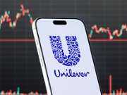 QIANJIANG, CHINA - FEBRUARY 26: In this photo illustration, a smartphone displays the logo of Unilever PLC (NYSE: UL), a British multinational consumer goods company specializing in food, beverages, personal care and household products, in front of a screen showing the company's latest stock market chart on February 26, 2026 in Qianjiang, Hubei Province, China. (Photo illustration by Cheng Xin/Getty Images)