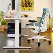 herman miller chair next to a desk with a pc and peripherals