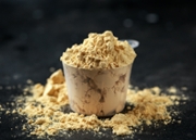 Scoop of Pea Vegan protein powder on dark rustic background. Sport nutrition