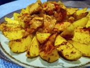 Idaho potatoes baked with pieces of turkey on a plate. Close-up.