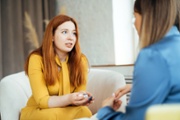 Two women in armchairs are sitting and talking. Woman psychologist practicing with patient women. Coach session between girlfriends. Therapist's gestures. Female talking in the office