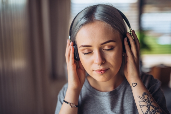 Portrait of young woman listening to music on headphones.