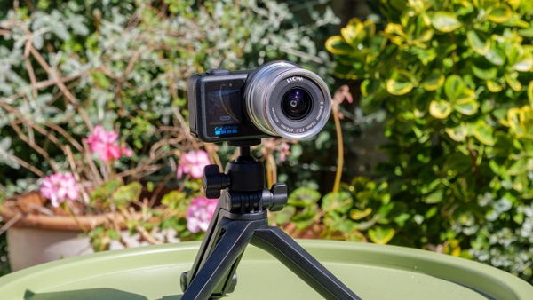 The GoPro Mission 1 Pro ILS camera set up on a tripod in a garden