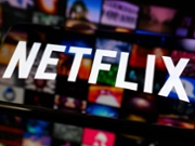 The Netflix logo appears on a smartphone screen placed on a reflective surface onto which a mosaic of streaming content is projected, as the streaming platform publishes its results for the first quarter of 2026, in Creteil, France, on April 17, 2026. (Photo by Samuel Boivin/NurPhoto via Getty Images)