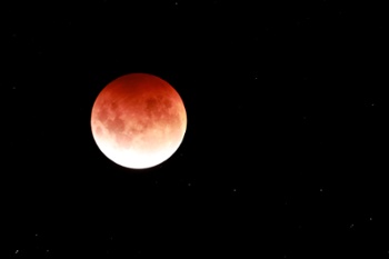 Why does the moon turn red during a total lunar eclipse?