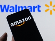 The Amazon logo is displayed on a mobile phone with the Walmart logo visible in the background in this photo illustration in Brussels, Belgium, on February 20, 2026. (Photo by Jonathan Raa/NurPhoto via Getty Images)