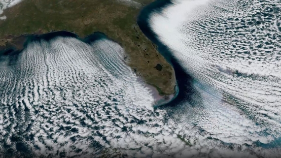 streaks of white clouds over a green peninsula