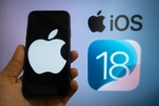 The Apple logo is seen with the iOS 18 operating system logo in the background on a mobile device in this illustration photo taken in L'Aquila, Italy, on June 20th, 2024.  (Photo by Lorenzo Di Cola/NurPhoto via Getty Images)