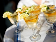 A closeup shows fancy little cocktails being passed on a tray.
