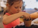 Girl planting seeds for seedlings in small recyclable peat pots, seedling container.Children learn to grow . High quality photo