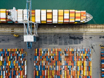 Drone aerial view of a cargo ship and cargo containers terminal at port.