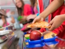 School children getting food in the cafeteria line.