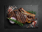 Aged beef Steak on the bone with rosemary and spices. A fried piece of meat. Free space for text.