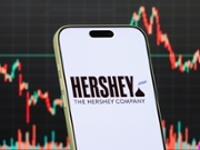 CHONGQING, CHINA - JANUARY 29: In this photo illustration, a smartphone displays the logo of The Hershey Company (NYSE: HSY), an American multinational food company best known for its chocolate and confectionery products, in front of a screen showing the company's latest stock market chart on January 29, 2026, in Chongqing, China. (Photo illustration by Cheng Xin/Getty Images)