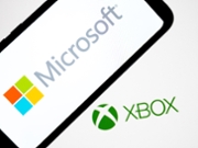 The Microsoft logo appears on a smartphone screen, and the Xbox logo serves as the background on a laptop computer screen in this photo illustration in Athens, Greece, on October 1, 2025. (Photo by Nikolas Kokovlis/NurPhoto via Getty Images)