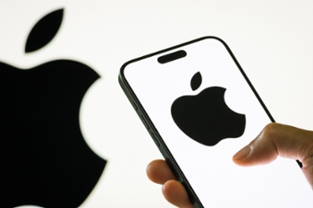 CHONGQING, CHINA - JULY 29: In this photo illustration, a person holds a smartphone displaying the logo of Apple Inc. (NASDAQ: AAPL), a leading American technology company known for its consumer electronics, software, and digital services, with the company's iconic apple logo visible in the background, on July 29, 2025 in Chongqing, China. (Photo illustration by Cheng Xin/Getty Images)