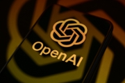 The OpenAI logo is displayed on a smartphone screen placed on a reflective surface onto which the company's icon is projected, in Creteil, France, on May 12, 2026. Daybreak is an AI-powered cybersecurity service designed to detect, analyze, and remediate software vulnerabilities more quickly. (Photo by Samuel Boivin/NurPhoto via Getty Images)