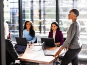 Female business owner speaking to office workers in modern conference room