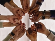People join hands in the center of a circle.