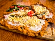 Breaded cutlet (Milanesa) with cream and cheese and a side of vegetables