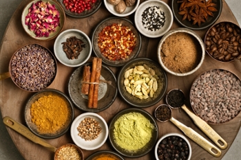 Top down image of many different types of colourful herbs and spices on wooden cut board, studio shot made with Nikon equipment