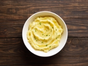 Mashed potatoes, boiled puree in bowl over wooden background with free space. Healthy comfort food. Top view, flat lay