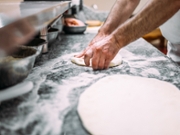 Chef preparing pizza dough.