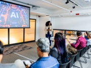 Mid adult businesswoman doing AI presentation to team in the modern office