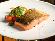Pan fried salmon with vegetables on white plate
