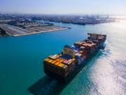 Experience the bustling activity of a thriving harbor with this aerial view of a cargo ship navigating through the sea. The expansive view showcases the maritime world in action, with the cargo ship gliding through the harbor against a backdrop of industry and trade. The bustling scene, filled with cargo containers, cranes, and maritime activity, epitomizes global commerce and transportation networks. This image perfectly conveys the vibrancy of international trade, logistics, and the interconnectedness of global economies. It's an ideal visual for projects portraying a thriving harbor's dynamic and vital essence.