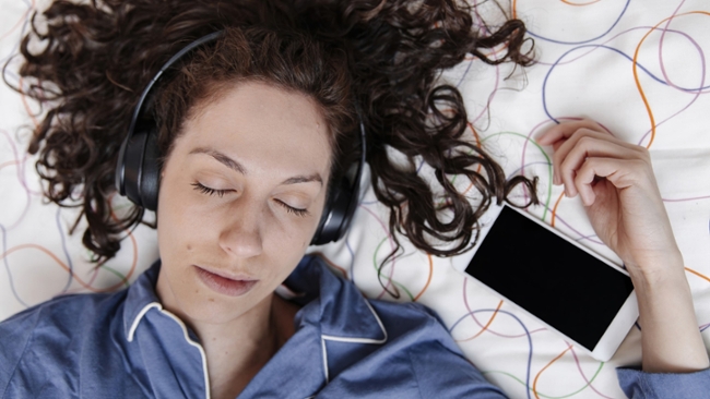 A woman listening to music on a phone