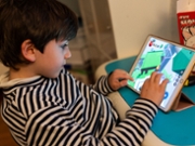 A seven-year-old child playing Roblox on an iPad tablet, inside his apartment in Paris, France, on December 26, 2025. Sitting at a table, focused on the screen, he interacts with a 3D playful universe typical of the platform. (Photo by Riccardo Milani / Hans Lucas / AFP via Getty Images)