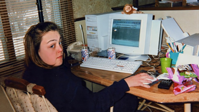 A young girl sat in front of an old PC