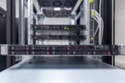 Rackmount chassis with installed server hardware in datacenter, front view from control panel units. Selective focus.