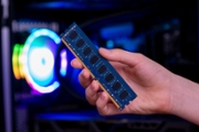 Hand holding ram memory chips inside gaming pc, symbolizing hardware shortages and rising prices driven by ai computing demand and semiconductor market pressure